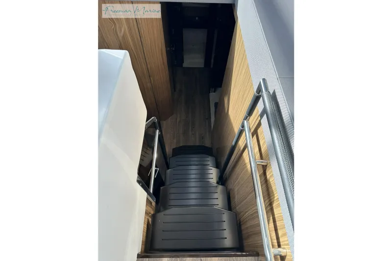 Slide: The Image of Staircase inside 2022 Cruisers Yachts 60 Cantius, featuring sleek wood and metal design. - 40
