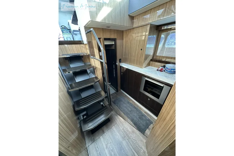 Slide: The Image of 2022 Cruisers Yachts 60 Cantius interior with modern kitchen and sleek staircase design. - 42