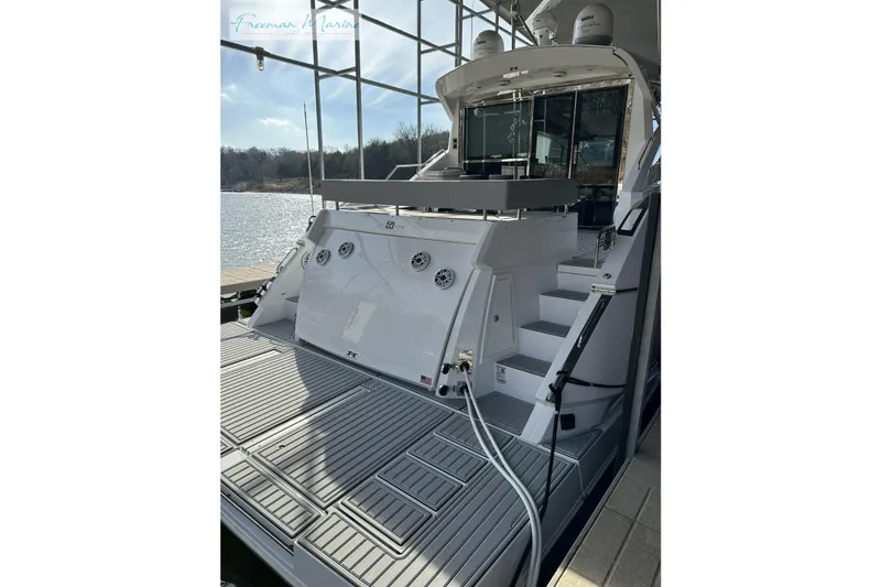 Slide: The Image of 2022 Cruisers Yachts 60 Cantius, rear view, docked with open deck and water backdrop. - 46