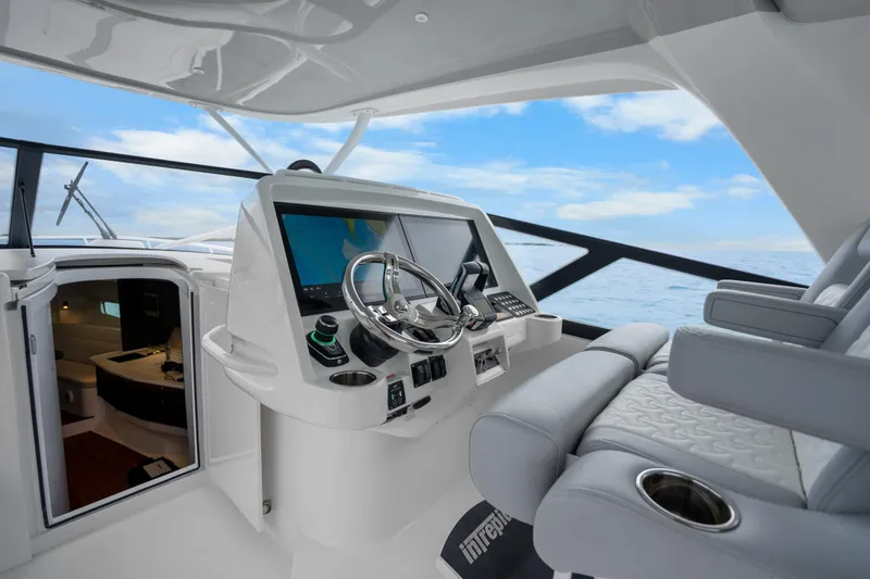 Slide: The Image of 2024 Intrepid 477 Evolution helm with modern navigation system and luxurious seating. - 12
