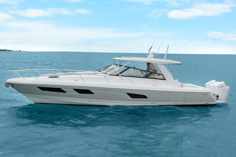 Slide: The Image of 2024 Intrepid 477 Evolution yacht cruising on open water under a clear blue sky. - 2