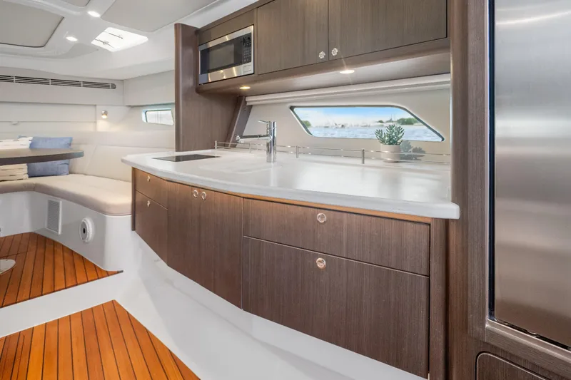 Slide: The Image of Luxurious 2024 Intrepid 477 Evolution yacht interior with modern kitchen and elegant wood finishes. - 20