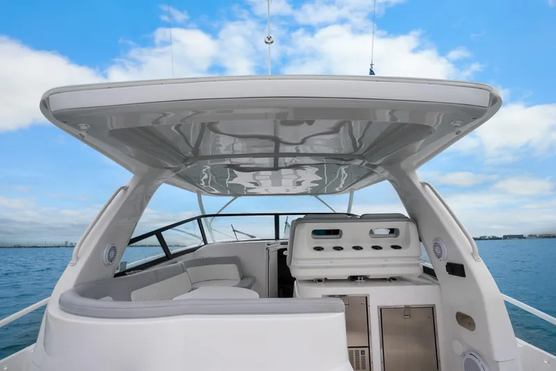 Slide: The Image of 2024 Intrepid 477 Evolution boat interior with seating and storage, under a clear blue sky. - 24