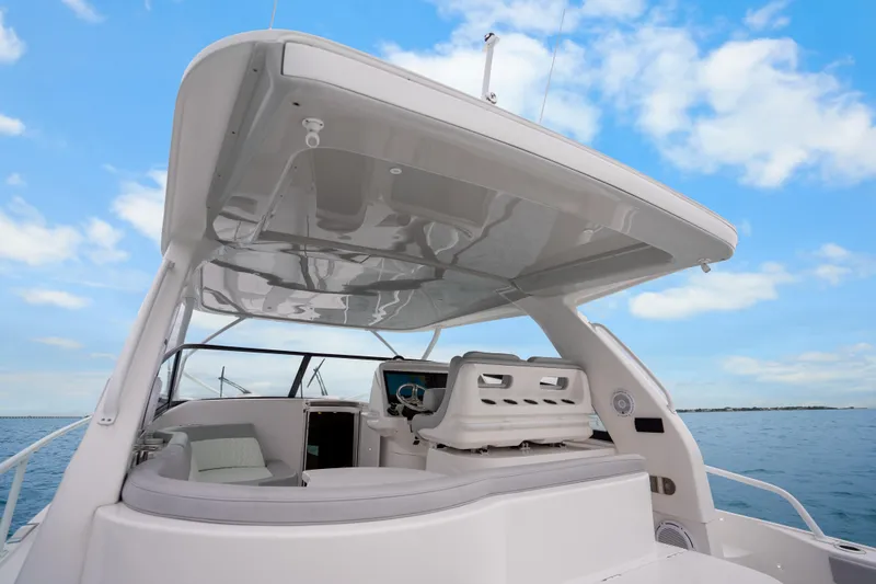 Slide: The Image of 2024 Intrepid 477 Evolution yacht with sleek design and spacious deck under blue sky. - 27