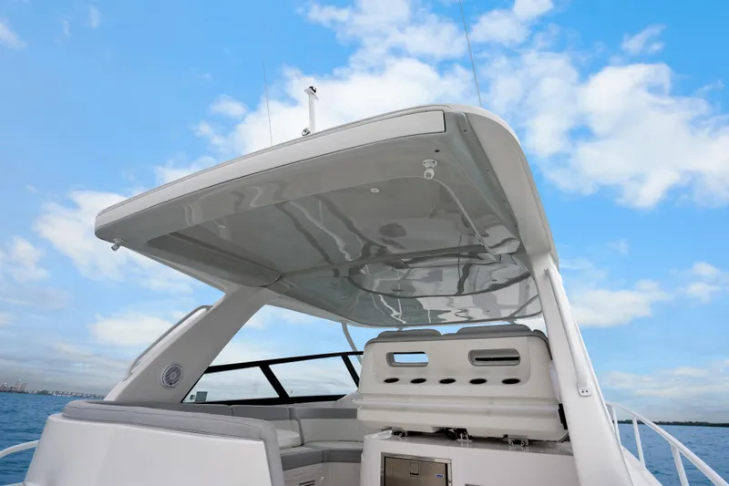 Slide: The Image of 2024 Intrepid 477 Evolution yacht with sleek design under a clear blue sky. - 28