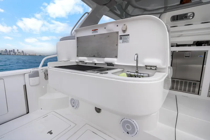 Slide: The Image of 2024 Intrepid 477 Evolution yacht with outdoor kitchen and sink, ocean view. - 29