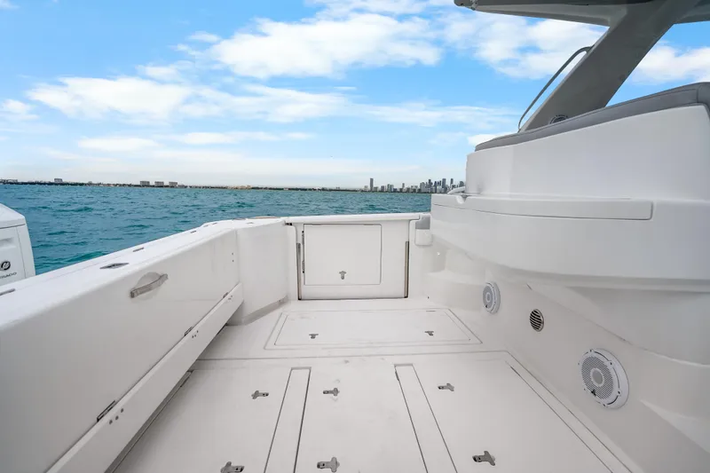 Slide: The Image of 2024 Intrepid 477 Evolution boat deck with ocean view and city skyline. - 30