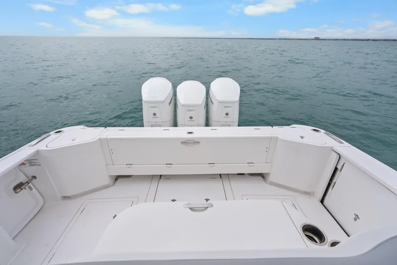 Slide: The Image of 2024 Intrepid 477 Evolution boat with triple outboard engines on open water. - 32