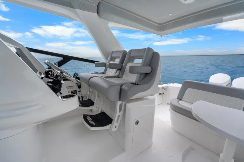 Slide: The Image of 2024 Intrepid 477 Evolution boat interior with modern helm and seating, ocean view. - 35