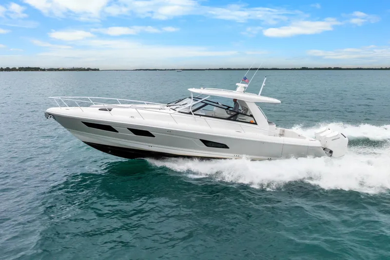 Slide: The Image of 2024 Intrepid 477 Evolution yacht cruising on open water under a clear blue sky. - 6