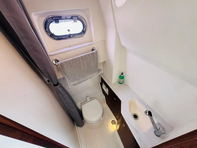 Slide: The Image of 2022 Pursuit S 358 Sport boat bathroom with sink, toilet, and window. - 11