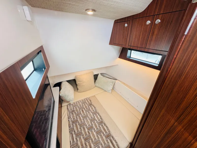 Slide: The Image of 2022 Pursuit S 358 Sport cabin interior with cozy seating and wooden cabinetry. - 12