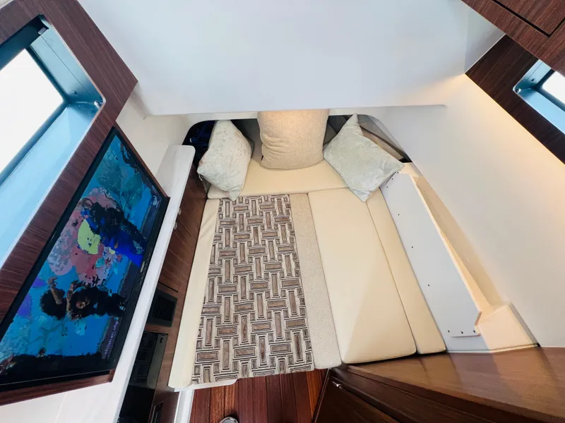Slide: The Image of 2022 Pursuit S 358 Sport cabin interior with cozy bed and decorative pillows. - 13