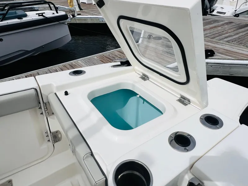 Slide: The Image of 2022 Pursuit S 358 Sport boat with open storage compartment at dock. - 15