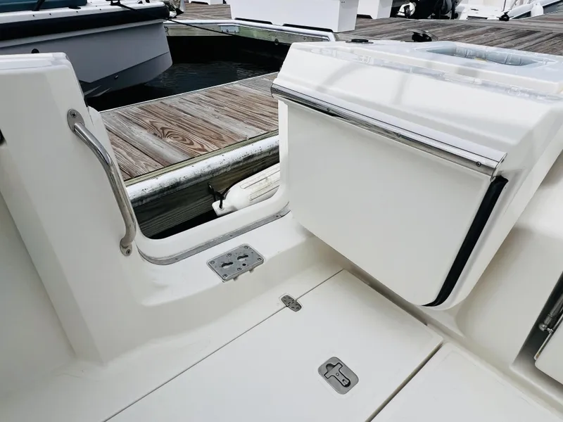 Slide: The Image of 2022 Pursuit S 358 Sport boat interior with open hatch and dock view. - 16