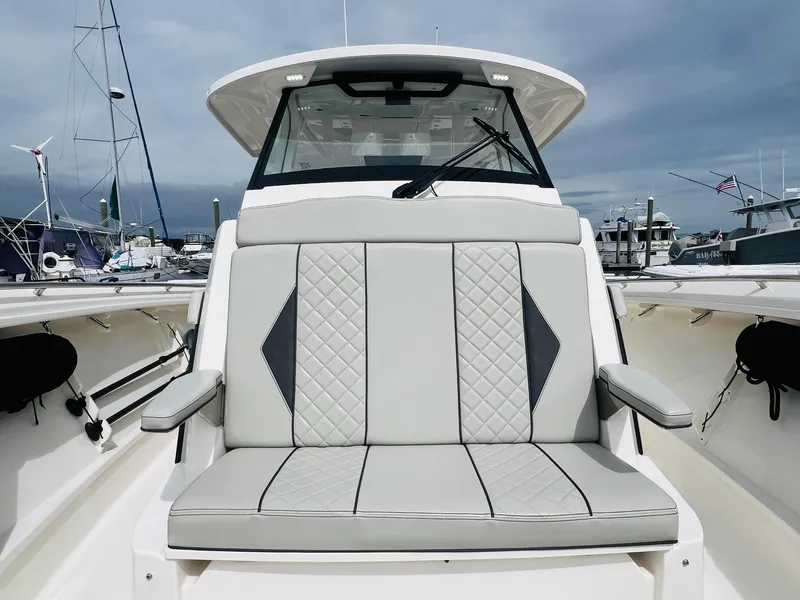 Slide: The Image of 2022 Pursuit S 358 Sport boat with cushioned seating at marina. - 28