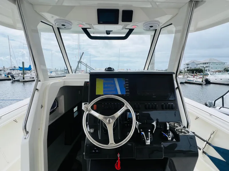 Slide: The Image of 2022 Pursuit S 358 Sport boat cockpit with steering wheel and navigation system. - 31