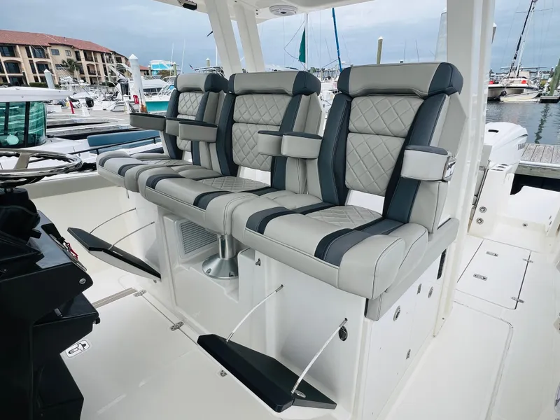 Slide: The Image of 2022 Pursuit S 358 Sport boat with luxurious seating at a marina. - 33