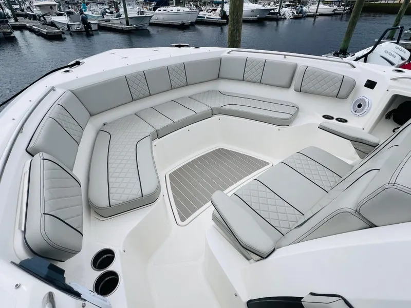 Slide: The Image of 2022 Pursuit S 358 Sport boat with spacious, luxurious seating in a marina setting. - 37