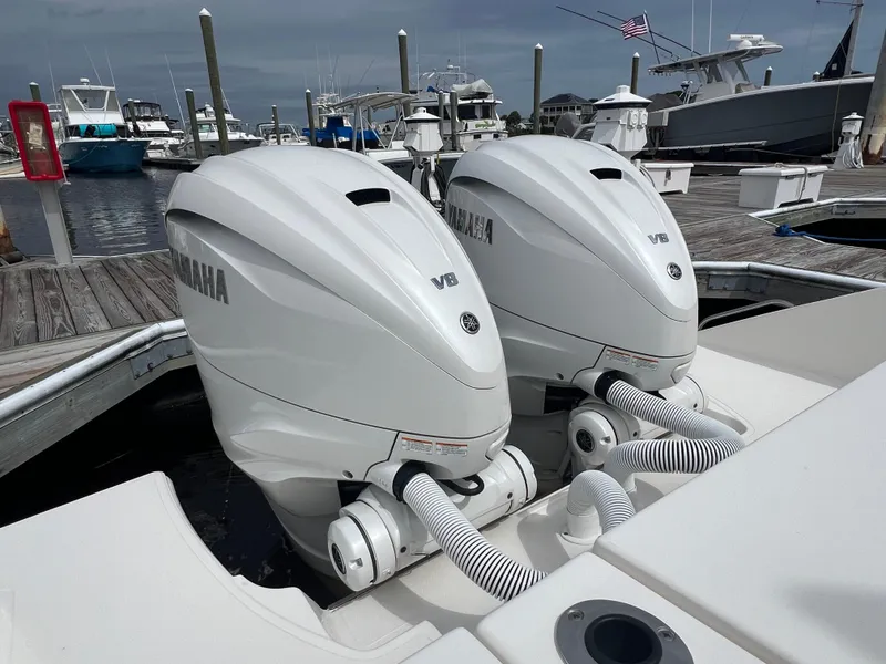 Slide: The Image of Twin Yamaha V8 engines on a 2022 Pursuit S 358 Sport boat at a marina. - 7