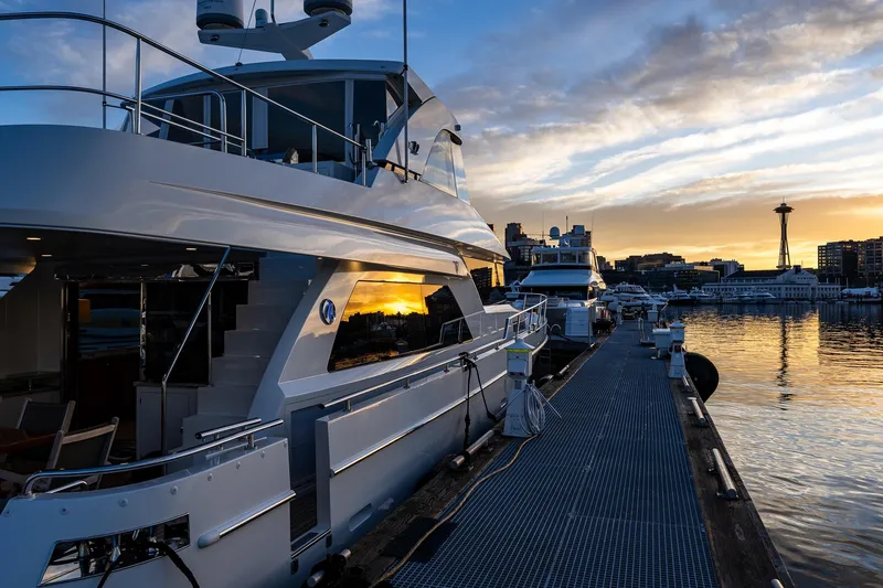 Slide: The Image of Luxury 2017 Ocean Alexander 72 Pilothouse yacht docked at sunset, city skyline in background. - 10