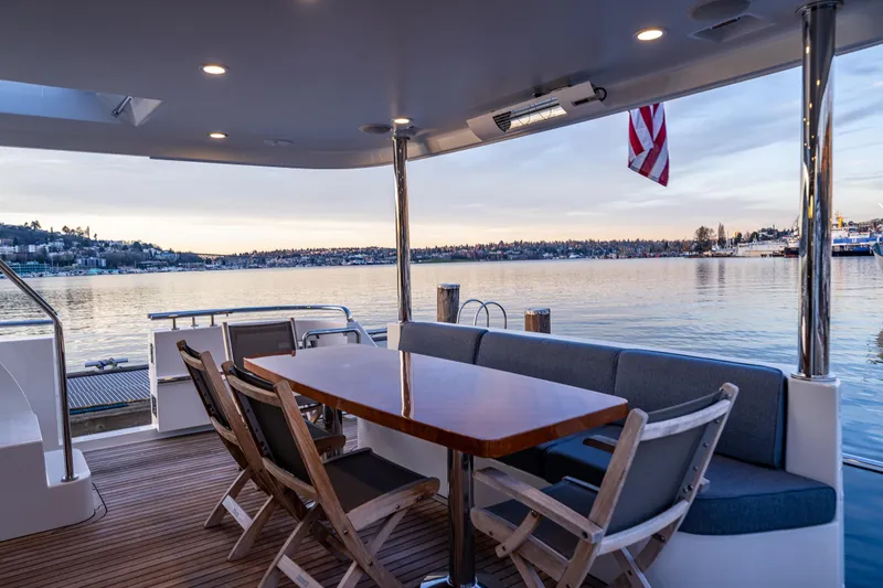Slide: The Image of Luxurious 2017 Ocean Alexander 72 Pilothouse yacht deck with seating, overlooking serene waters. - 11