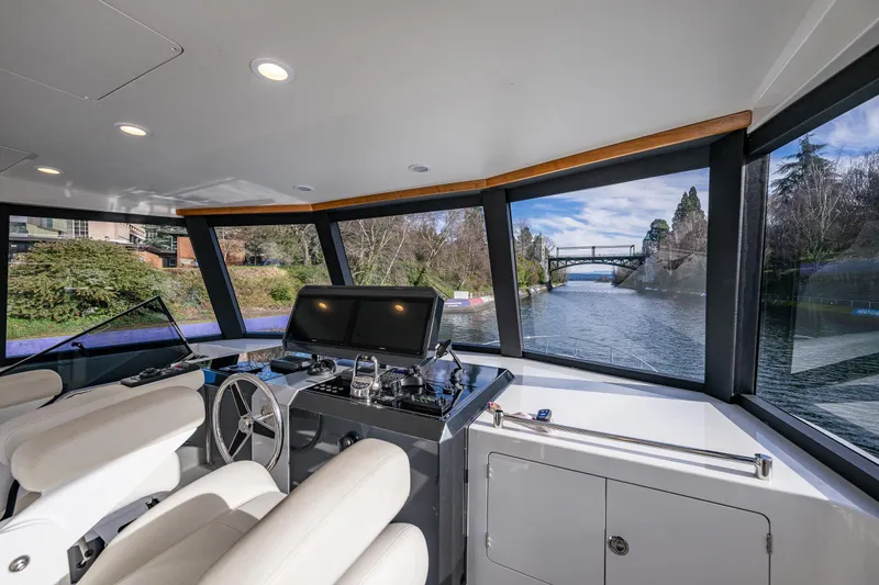 Slide: The Image of Pilothouse interior of 2017 Ocean Alexander 72, featuring modern controls and scenic waterway view. - 15