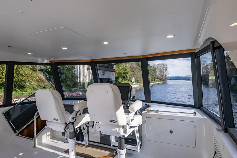 Slide: The Image of Pilothouse interior of 2017 Ocean Alexander 72, featuring dual captain chairs and panoramic windows. - 16