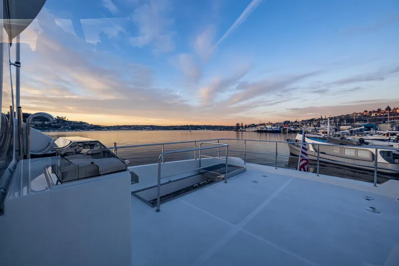 Slide: The Image of Ocean Alexander 72 Pilothouse 2017 yacht deck at sunset, overlooking a serene marina. - 21