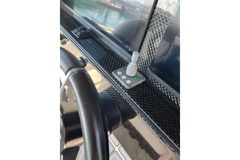 Slide: The Image of 2019 Nor-Tech 390 Sport Center Console dashboard with joystick and carbon fiber finish. - 11