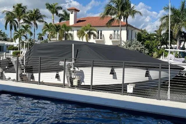 Slide: The Image of 2019 Nor-Tech 390 Sport Center Console boat covered, docked near a waterfront home. - 13