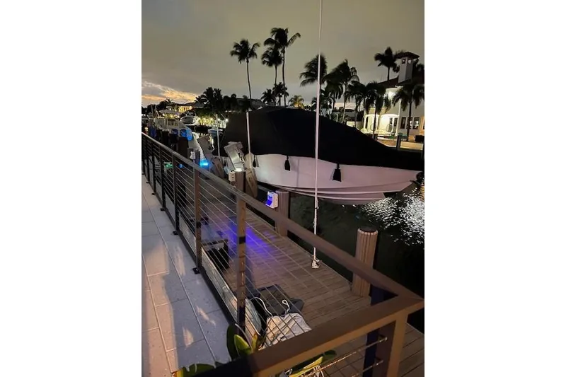 Slide: The Image of 2019 Nor-Tech 390 Sport Center Console docked at night, surrounded by palm trees. - 14