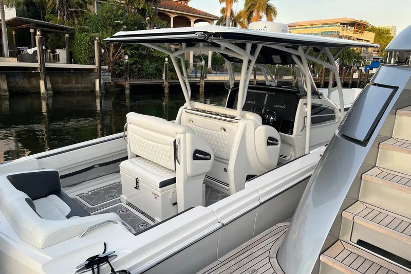 Slide: The Image of 2019 Nor-Tech 390 Sport Center Console boat docked, featuring sleek design and modern amenities. - 3