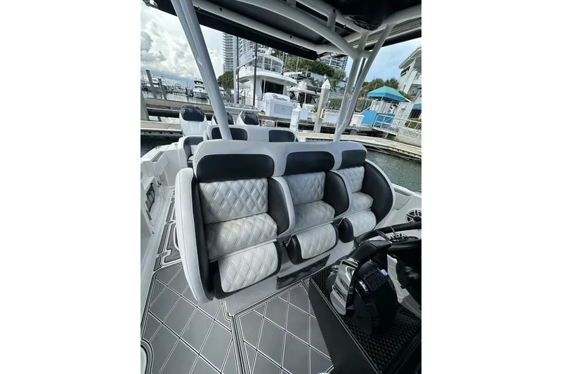 Slide: The Image of 2019 Nor-Tech 390 Sport Center Console with luxurious seating at a marina. - 5