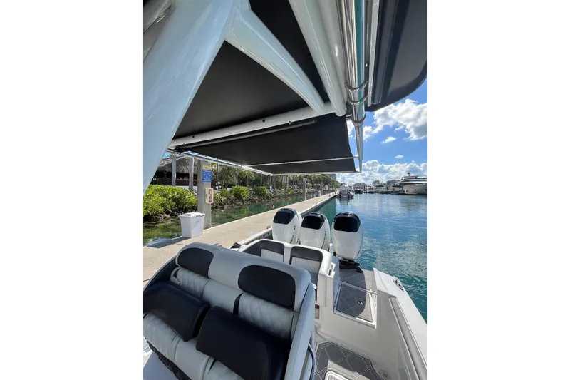 Slide: The Image of 2019 Nor-Tech 390 Sport Center Console boat docked by a marina under a sunny sky. - 9