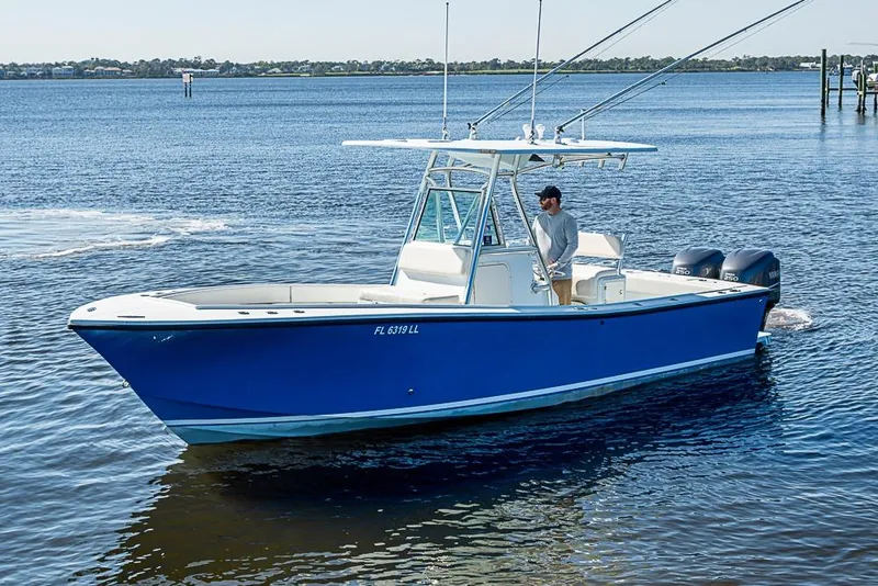 The Image of Blue 2000 Regulator 26 Forward Seating boat on calm water, featuring dual outboard engines. - 0