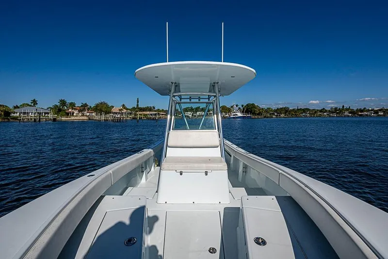 Slide: The Image of 2000 Regulator 26 Forward Seating boat on calm water under clear blue sky. - 5