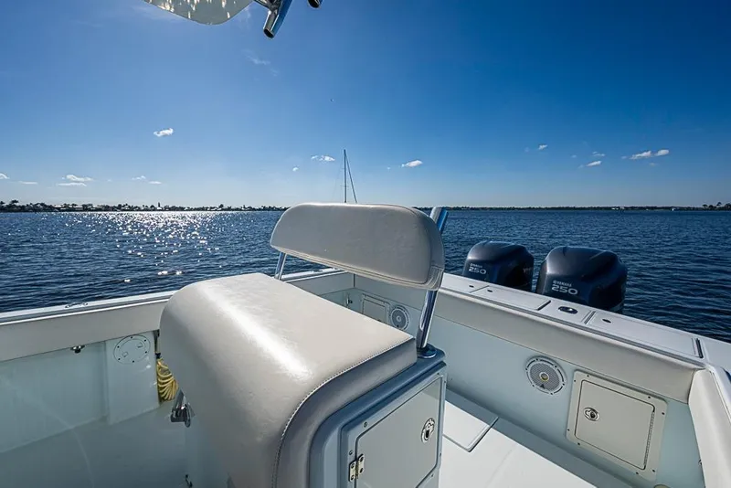 Slide: The Image of 2000 Regulator 26 Forward Seating boat on calm water, sunny day, dual Yamaha engines. - 8