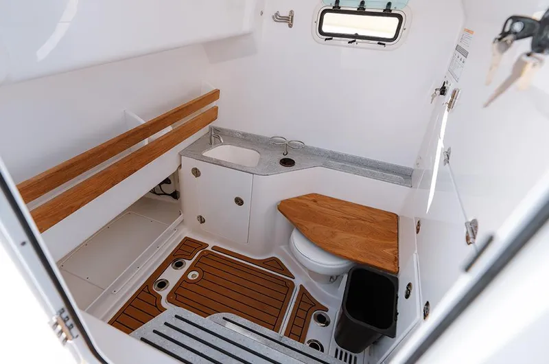 Slide: The Image of Manufacturer Provided Image: 2025 Everglades 315 Center Console boat interior with sink and toilet. - 9