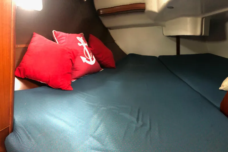 Slide: The Image of Cozy cabin interior of 2003 Beneteau 361 sailboat with red anchor-themed pillows. - 10