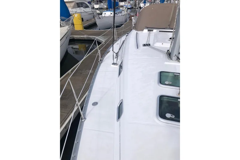 Slide: The Image of 2003 Beneteau 361 sailboat deck view at marina, showcasing sleek design and moored vessels. - 16