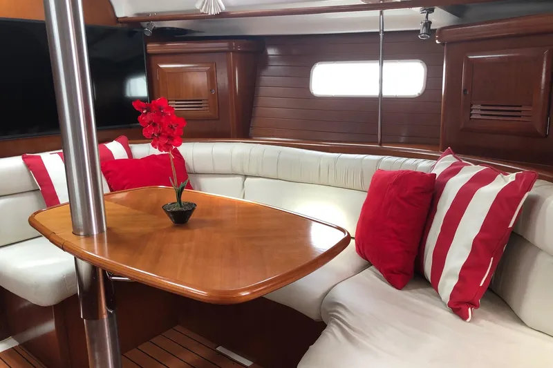 Slide: The Image of Interior of 2003 Beneteau 361 yacht with elegant seating and red accents. - 2