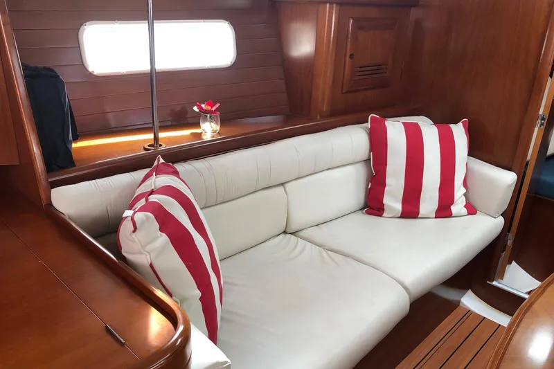 Slide: The Image of Interior of 2003 Beneteau 361 yacht with white sofa and striped pillows. - 3