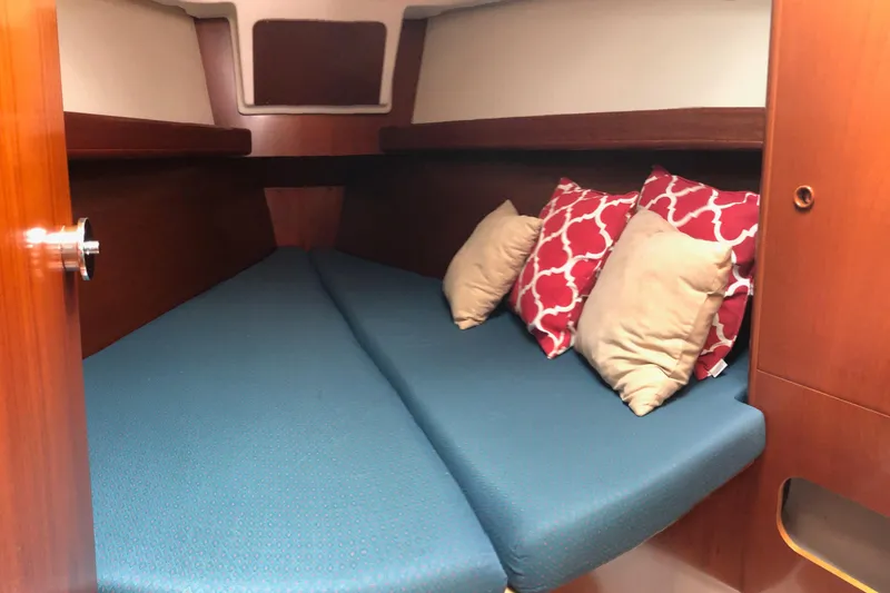 Slide: The Image of Cozy cabin interior of 2003 Beneteau 361 sailboat with blue bedding and decorative pillows. - 5