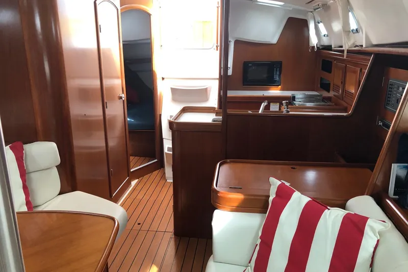 Slide: The Image of Interior of 2003 Beneteau 361 yacht with wood finish and striped cushions. - 8