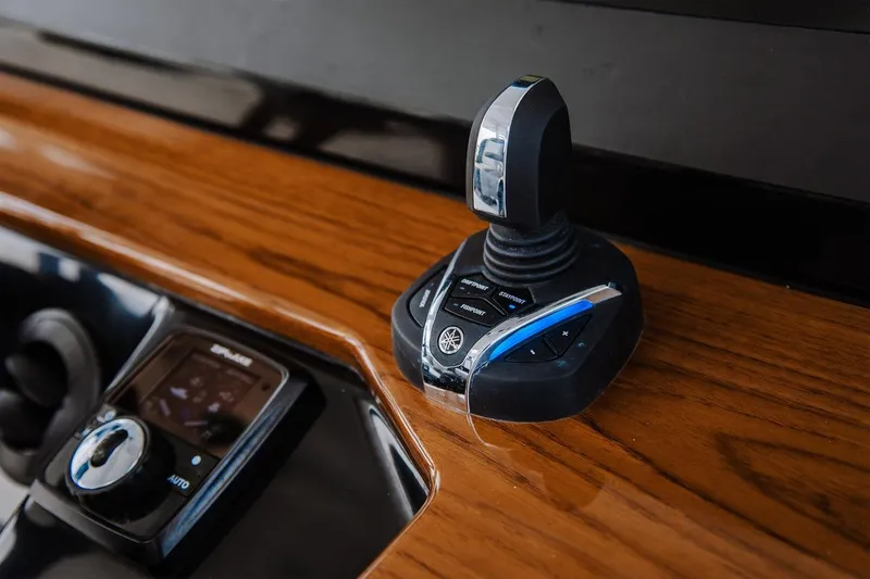 Slide: The Image of 2026 Everglades 395 Center Console joystick control on wooden dashboard. - 15