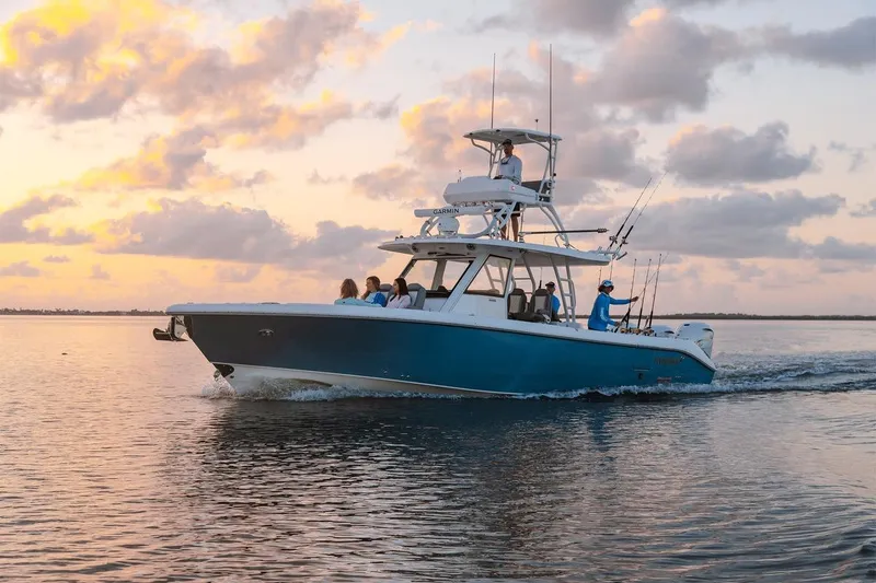 Slide: The Image of 2026 Everglades 395 Center Console boat cruising at sunset with passengers onboard. - 17