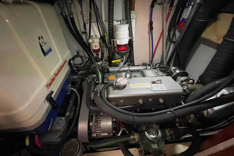 Slide: The Image of Engine compartment of a 2010 Hunter 45 Center Cockpit sailboat, showing detailed components and wiring. - 64