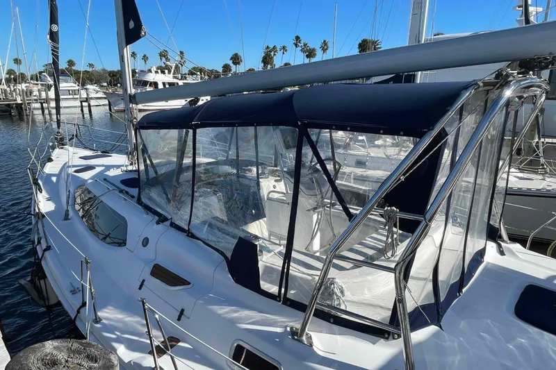 Slide: The Image of 2010 Hunter 45 Center Cockpit sailboat docked in a marina under clear blue skies. - 90