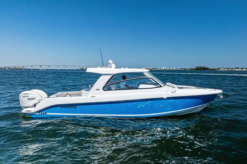 Slide: The Image of Manufacturer Provided Image: 2025 Everglades 367 CX boat cruising on open water under clear blue skies. - 1